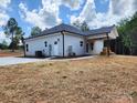 Rear exterior showcases a covered patio, a white siding with black accents, and a green lawn at 1247 Beltline Rd # 1, Chester, SC 29706