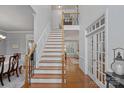 Inviting foyer with hardwood floors, a staircase with wooden handrails, and a view into multiple rooms at 1400 Coachman Dr, Waxhaw, NC 28173