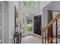 Bright foyer with hardwood floors, soaring ceilings, an elegant staircase, and a view of the front yard at 1400 Coachman Dr, Waxhaw, NC 28173