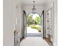 Elegant foyer featuring an arched doorway with black french doors and a view of the landscaped front yard at 1504 Alydar Ct, Waxhaw, NC 28173