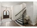 Classic staircase with black handrail and steps, complemented by white walls and wood flooring at 1504 Alydar Ct, Waxhaw, NC 28173