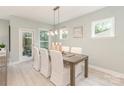 Dining area featuring a wooden table with white chairs and a contemporary light fixture at 2008 Waxhaw Crossing Dr, Waxhaw, NC 28205