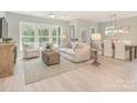 Open-concept living room and dining area with hardwood floors, ample natural light, and modern furnishings at 2008 Waxhaw Crossing Dr, Waxhaw, NC 28205