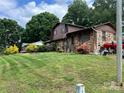 Brick home showing manicured lawn, lush landscaping, fountain, and neighboring house at 204 Aspen Dr, Gastonia, NC 28052