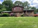 Two-story brick home with a well-manicured lawn, fountain, and mature landscaping, adding to its curb appeal at 204 Aspen Dr, Gastonia, NC 28052