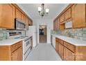 Functional kitchen with white appliances, tiled backsplash, and ample wooden cabinetry at 212 Pointe Cir, Rock Hill, SC 29732