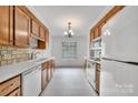 Bright kitchen with white tile floors, appliances, and wooden cabinets for ample storage at 212 Pointe Cir, Rock Hill, SC 29732