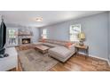 Cozy living room with fireplace, large sectional sofa, hardwood floors, and ample natural light at 2342 Castlecomer Dr, Charlotte, NC 28262