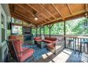 Relaxing covered patio with wood ceiling, comfortable seating, grill, and bar, perfect for outdoor entertaining at 2342 Castlecomer Dr, Charlotte, NC 28262
