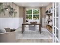 Well-lit home office showcasing white wainscoting, hardwood floors, and a view to trees at 2635 Tillman St, Monroe, NC 28112