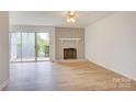 Bright living room featuring hardwood floors, brick fireplace, and sliding glass doors to the outside at 2916 Iron Gate Ln, Charlotte, NC 28212