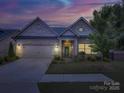Inviting home exterior at dusk, featuring manicured landscaping and warm lighting at 3002 Portico Pl, Tega Cay, SC 29708