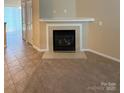 Close-up of a stylish fireplace with tiled hearth and mantel, seamlessly blending carpet and tile flooring at 3527 Creeping Flora Ln, Charlotte, NC 28216
