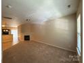 Spacious living area with neutral walls, plush carpeting, a fireplace, and natural light creates a warm and inviting atmosphere at 3527 Creeping Flora Ln, Charlotte, NC 28216