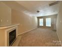 Spacious living room featuring a cozy fireplace and neutral carpeting at 3527 Creeping Flora Ln, Charlotte, NC 28216