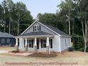 Stylish home with a covered front porch, gray siding, and well-manicured lawn at 404 N Peterson St, Stanley, NC 28164