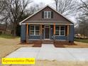 Inviting home with a cozy front porch, blue siding, and Craftsman-style details at 404 N Peterson St, Stanley, NC 28164