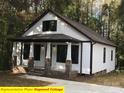 Beautiful cottage featuring a covered porch with brick supports and dark trim at 404 N Peterson St, Stanley, NC 28164