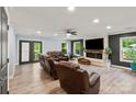 Spacious living room with a stone fireplace, hardwood floors, ceiling fan, and plentiful natural light at 430 Edgegreen Dr, Charlotte, NC 28217