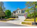 Street view of a two-story home with stone facade, attached garage, and an American flag at 5070 Saint Clair St, Fort Mill, SC 29715