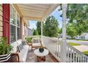 Comfortable front porch seating area with stylish white furniture and a view of the neighborhood at 5114 Daffodil Ln, Concord, NC 28025
