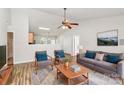 Bright living room featuring a ceiling fan, modern furniture, and an open layout into the kitchen at 5114 Daffodil Ln, Concord, NC 28025