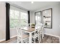 Sunlit dining area features a wood table, seating for six, large windows and stylish décor at 5782 Knox Ln, Kannapolis, NC 28081