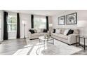 Inviting living room features two sofas, a glass coffee table, and large windows for abundant natural light at 5782 Knox Ln, Kannapolis, NC 28081