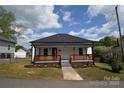 Charming home with a inviting front porch with a black roof, and landscaped front yard at 62 Fourth St, Cramerton, NC 28032