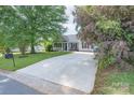 Spacious driveway leads to a well-maintained single-story home, framed by mature trees and landscaping at 744 Chipmeadow Ln, York, SC 29745