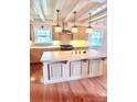 Kitchen island has ample counter space, light fixtures, and wood floors at 7811 Babe Stillwell Farm Rd, Huntersville, NC 28078