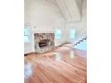 Bright living room featuring a stone fireplace and hardwood floors, perfect for cozy evenings at 7811 Babe Stillwell Farm Rd, Huntersville, NC 28078