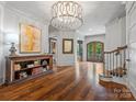 Spacious foyer boasting hardwood floors, a decorative chandelier, and an adjacent staircase at 7906 Skye Lochs Dr, Waxhaw, NC 28173