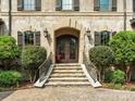 Grand entrance featuring stone steps, ornate iron doors, and meticulously maintained shrubbery at 7906 Skye Lochs Dr, Waxhaw, NC 28173