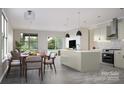 Open concept kitchen and dining area with a large island, stainless steel appliances, and views of the backyard at 808 Garringer Pl, Charlotte, NC 28208
