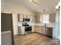Spacious kitchen featuring stainless steel appliances, granite countertops, and wood flooring at 8809 Reedy Creek Rd, Charlotte, NC 28215
