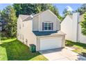 Side view of a charming two-story house with a two-car garage and well-maintained lawn at 10330 Seedling Ln, Charlotte, NC 28214