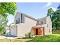 View of charming house with a two-car garage, red brick entrance, and green front yard at 10330 Seedling Ln, Charlotte, NC 28214