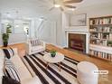 Bright living room featuring a fireplace, modern furnishings, and beautiful hardwood floors at 1043 Park West Dr, Charlotte, NC 28209