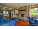 Cozy living room featuring a stone fireplace, hardwood floors, and comfortable blue furniture at 106 Chatworth Ln, Mooresville, NC 28117