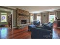 Bright living room boasting a stone fireplace, hardwood floors, and comfortable seating at 106 Chatworth Ln, Mooresville, NC 28117