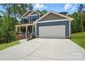 Charming two-story home with blue siding, a two-car garage, and a welcoming front porch at 1118 Allman Ext, Mount Pleasant, NC 28124