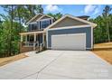 Charming two-story home featuring a brick porch, blue siding, and attached two car garage at 1118 Allman Ext, Mount Pleasant, NC 28124