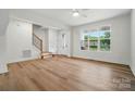 Bright living room with wood flooring, white walls, a staircase, and a large window at 1118 Allman Ext, Mount Pleasant, NC 28124