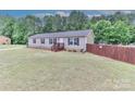 Comfortable home with neat yard and a wooden fence providing privacy, creating a cozy outdoor space at 119 Marietta Rd, Mooresville, NC 28117