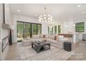 Bright living room featuring a fireplace, modern lighting, and access to the outdoor deck at 1534 Easy St, Belmont, NC 28012
