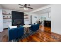 Bright living room features a brick fireplace, hardwood floors, and access to dining area at 2054 Hickory Hills Dr, Denver, NC 28037