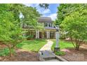 Inviting two-story home with a stone pathway leading to a covered porch, surrounded by lush landscaping at 2126 Norton Rd, Charlotte, NC 28207