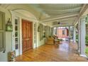 Inviting front porch featuring wicker furniture, stylish lanterns, and a beautiful wooden door at 2126 Norton Rd, Charlotte, NC 28207