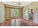 Dining area with hardwood floors and a bright window, adjacent to the red kitchen at 252 7Th Se St, Hickory, NC 28602